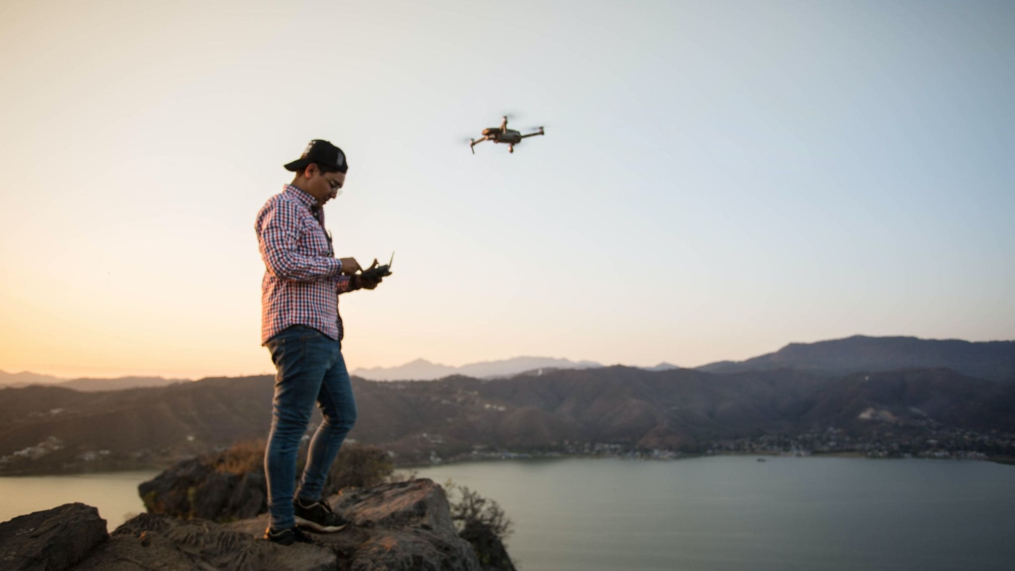 Man flying a drone near a body of water